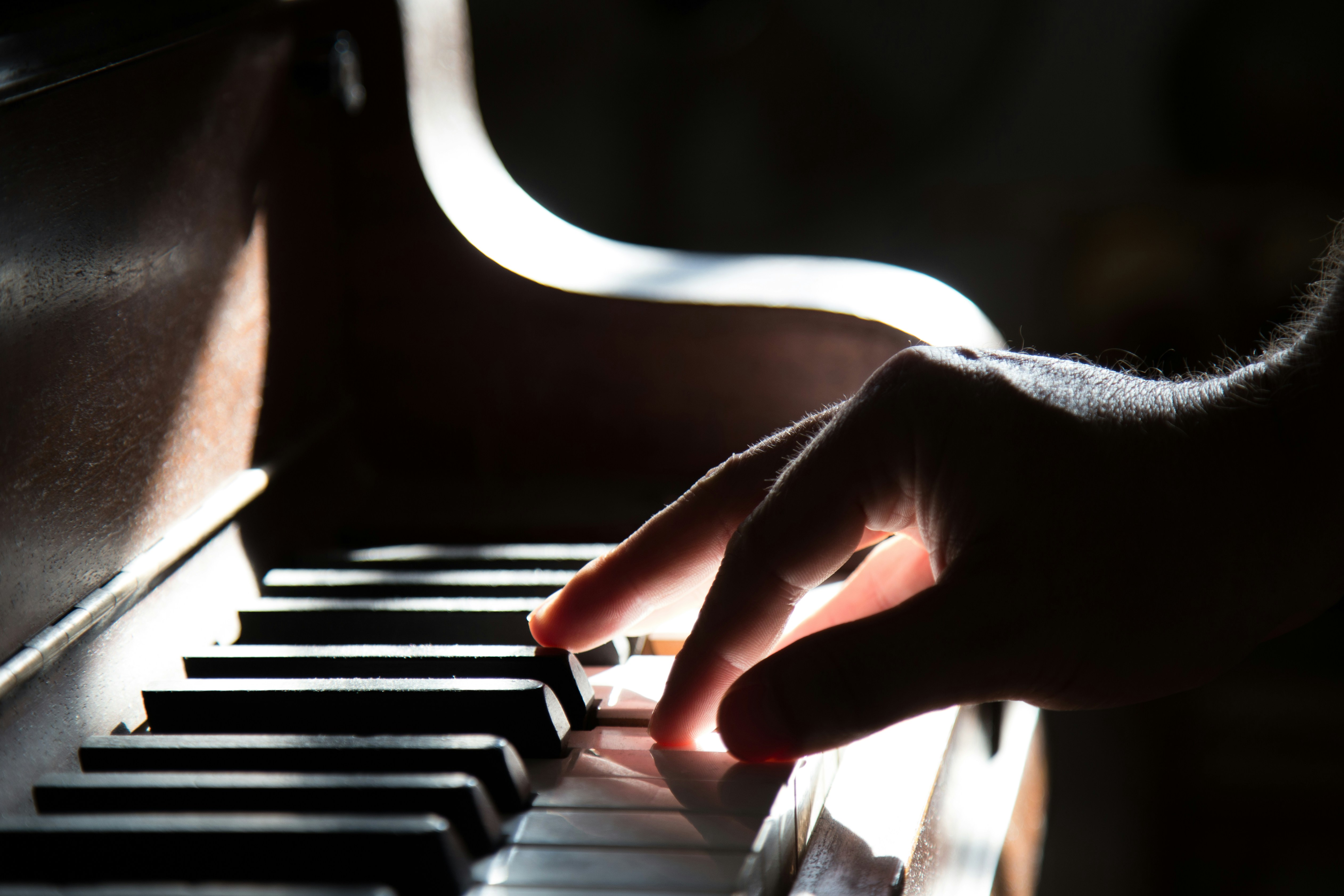 Hand drückt Tasten auf einem Klavier