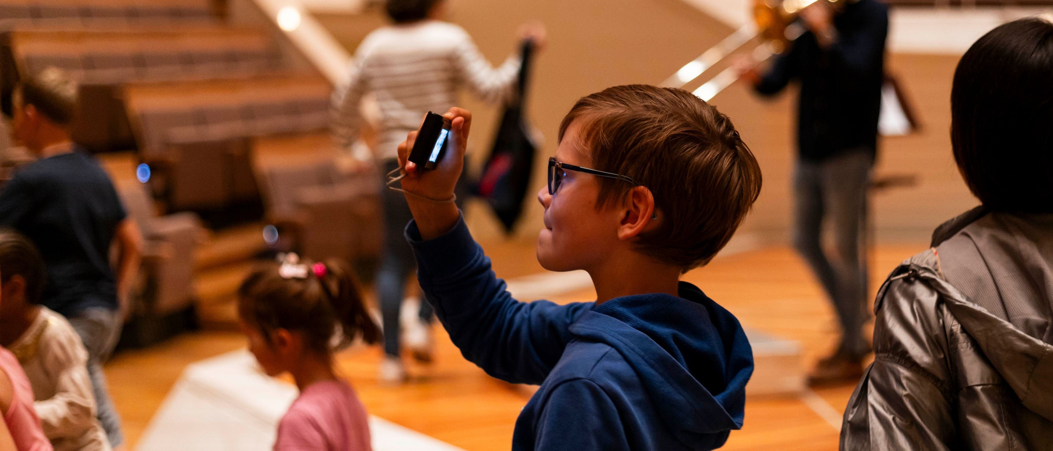 Boy takes a photo with his mobile phone in the Philharmonie.