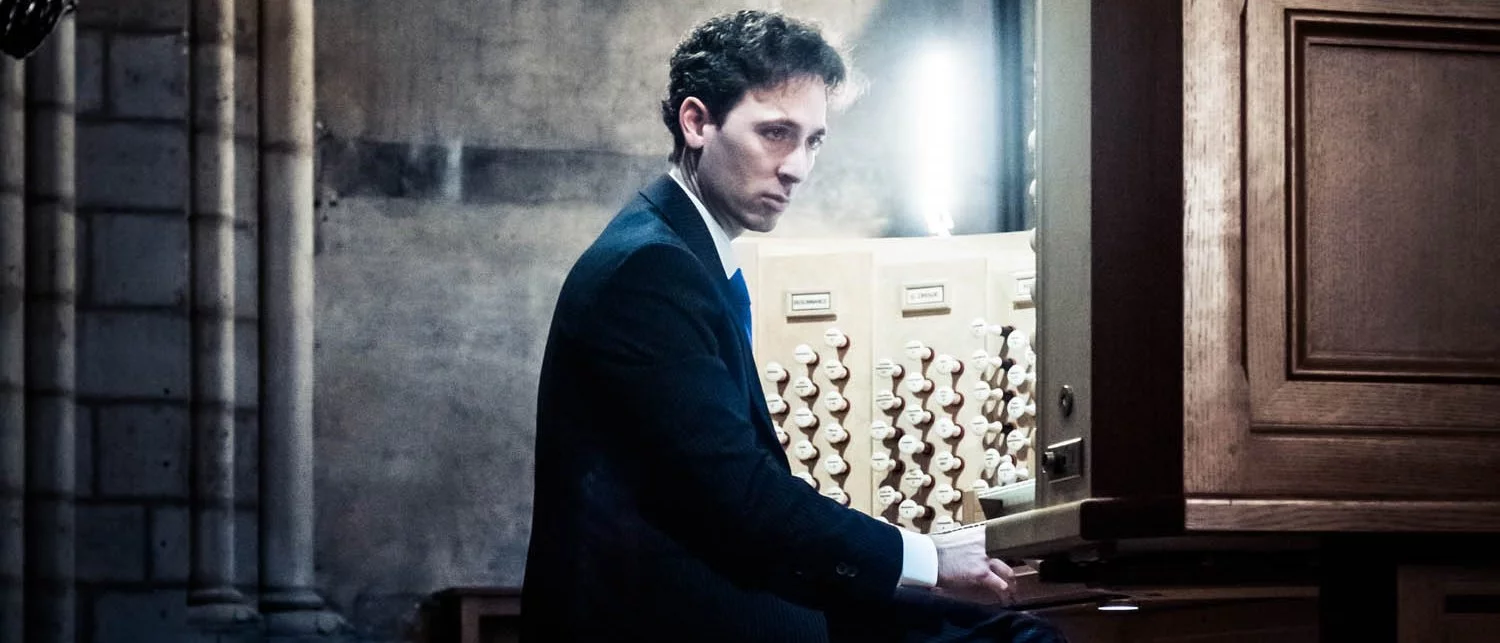 Vincent Dubois sits at an organ