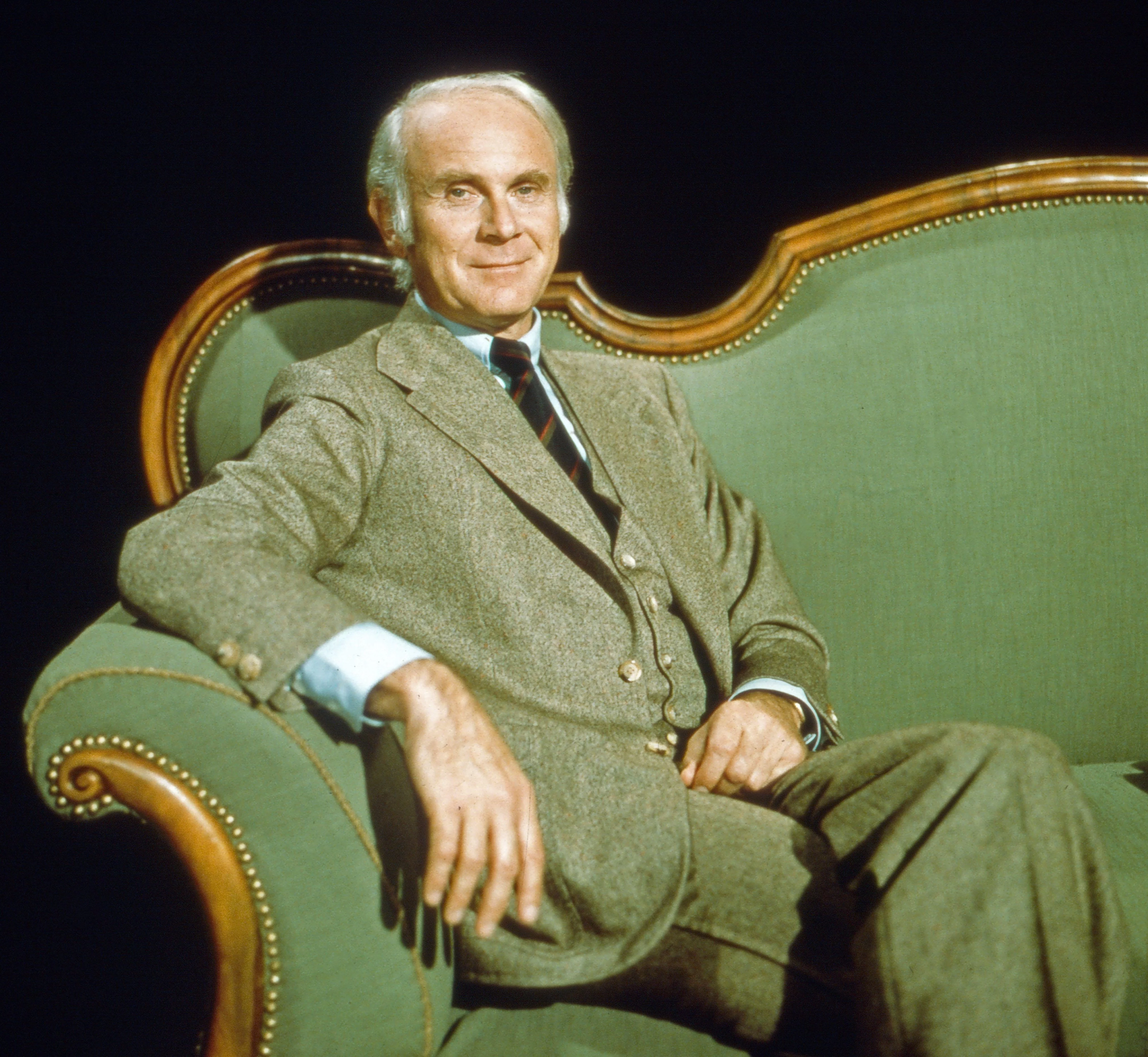 Loriot sitzt auf einem alten grünen Sofa