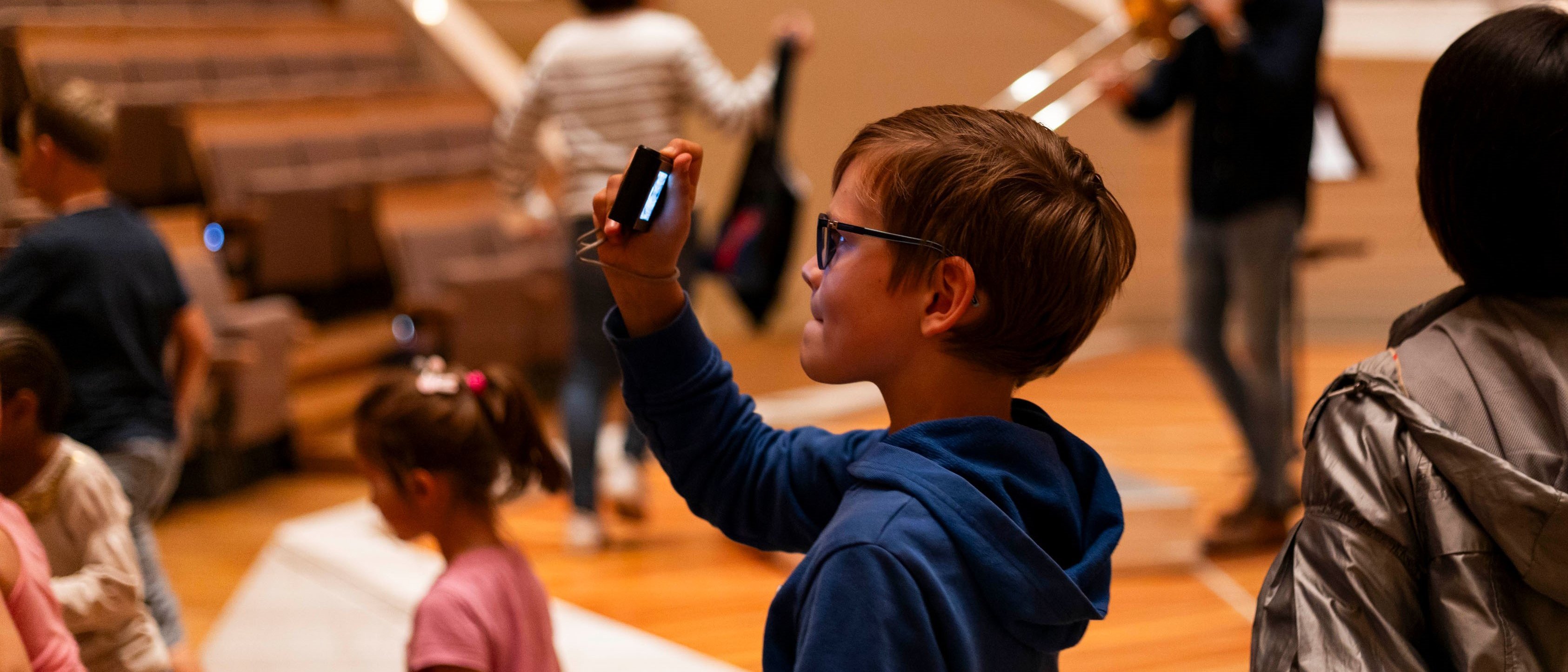 Junge macht mit seinem Handy ein Foto in der Philharmonie.