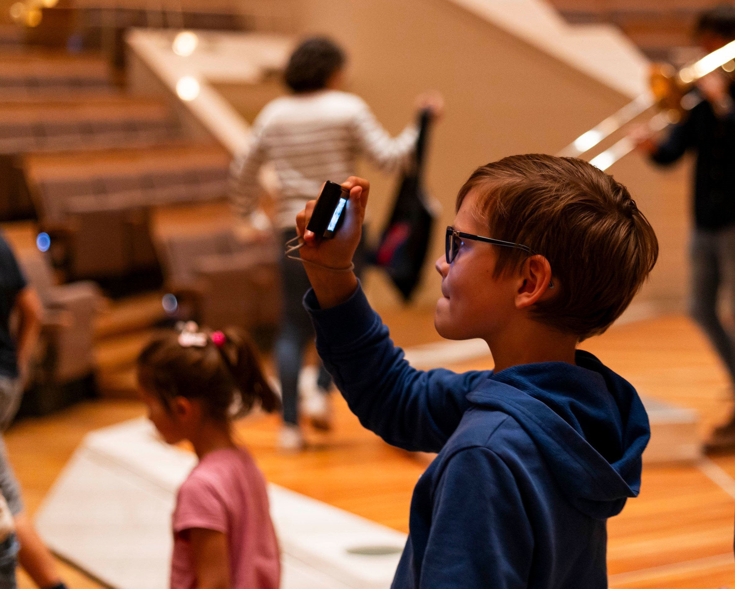 Junge macht mit seinem Handy ein Foto in der Philharmonie.