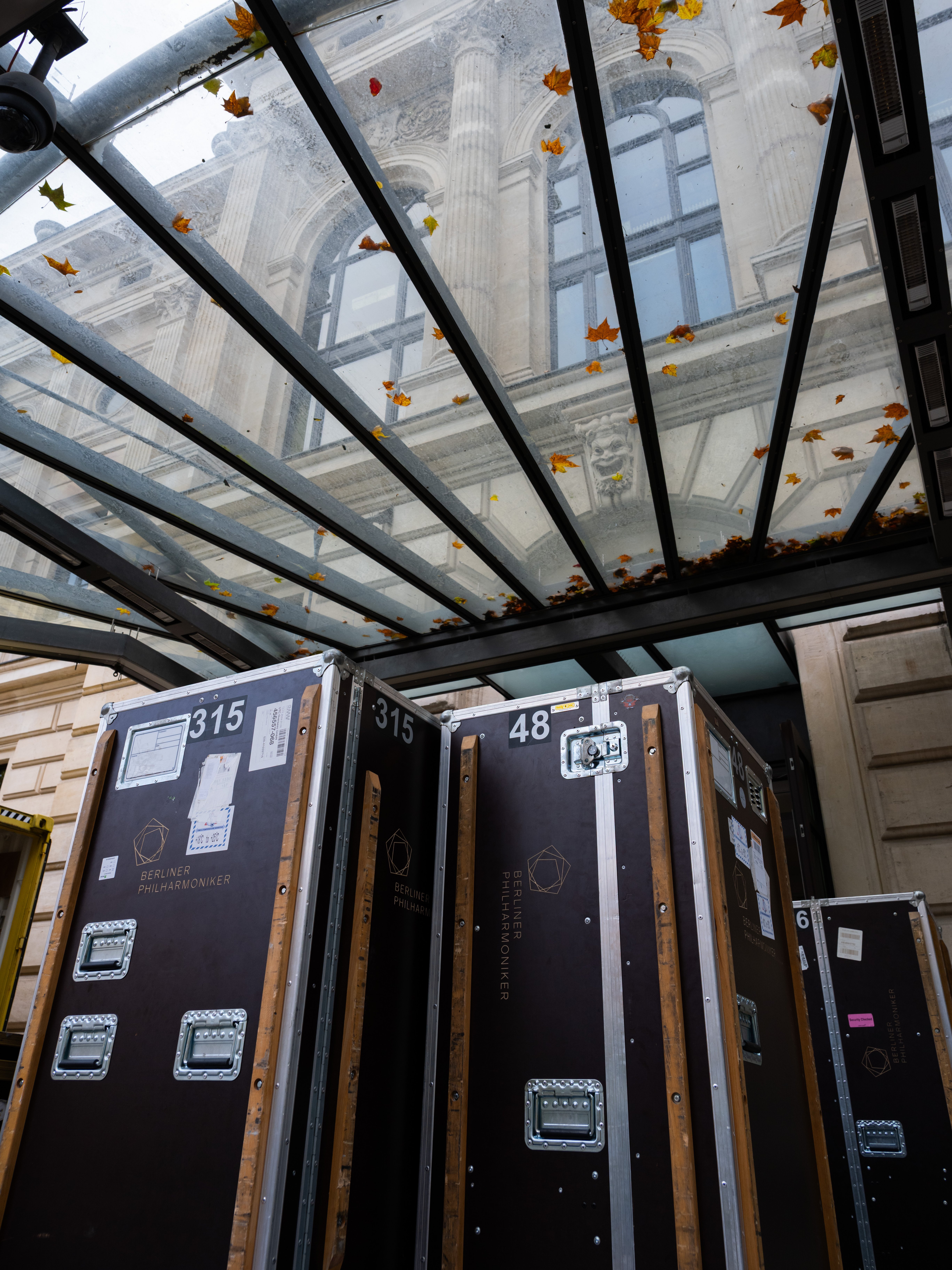 Under the glass roof stand numbered instrument cases from the orchestra.