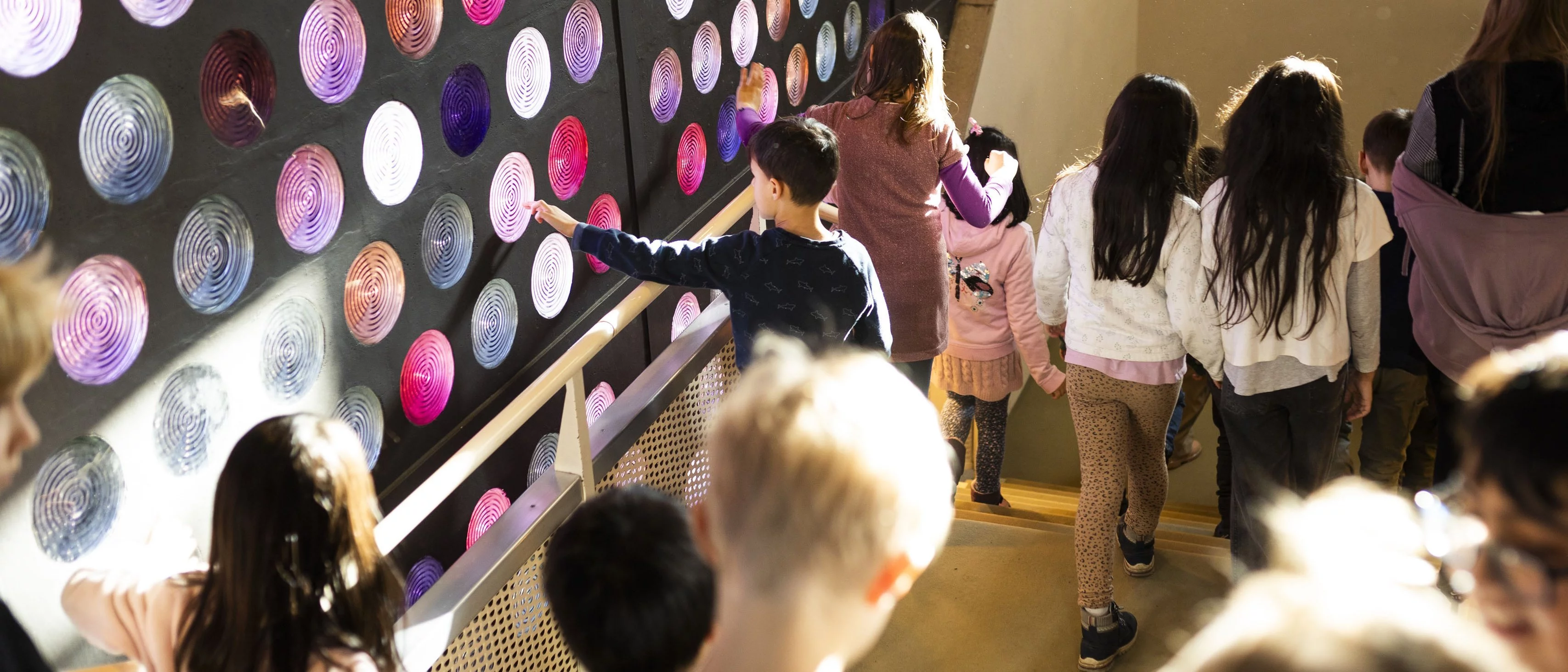 Children walk along colourful glass blocks in the Philharmonie