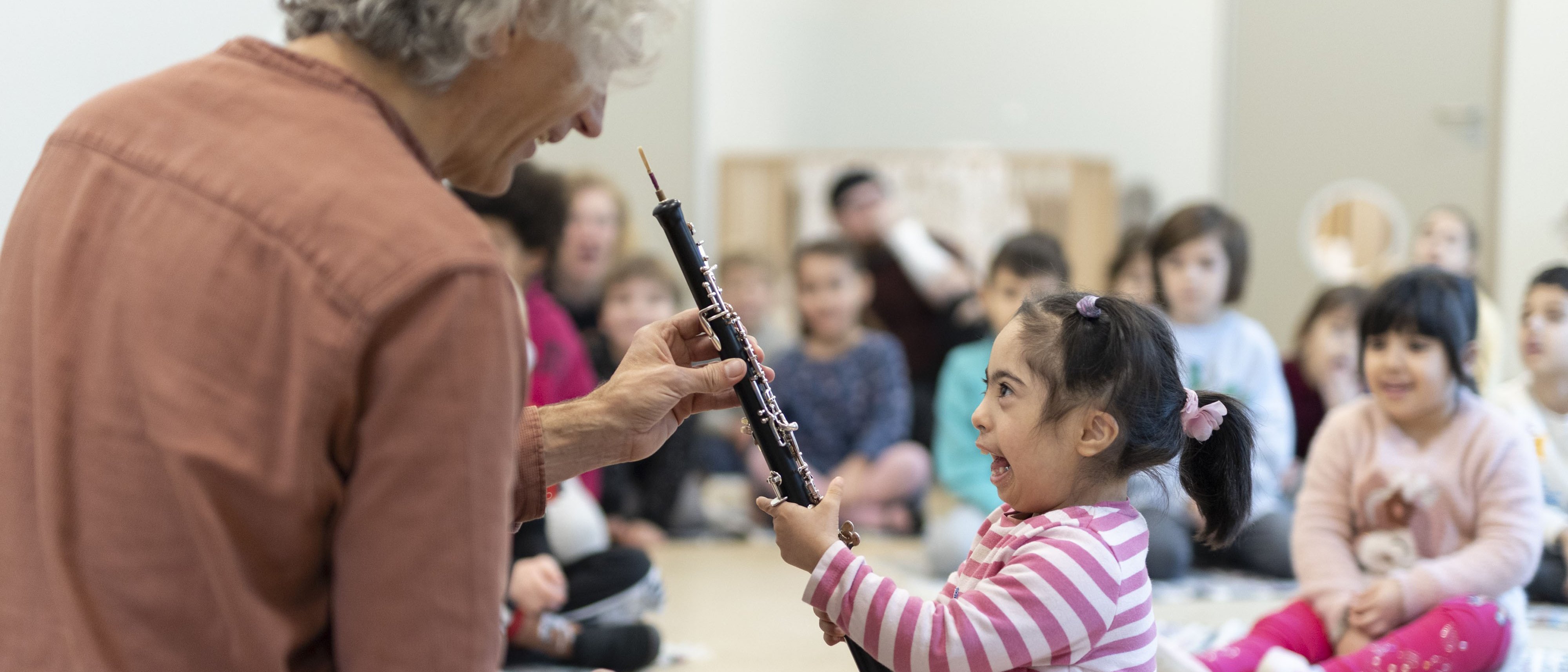 Musiker zeigt kleinem Kind eine Oboe