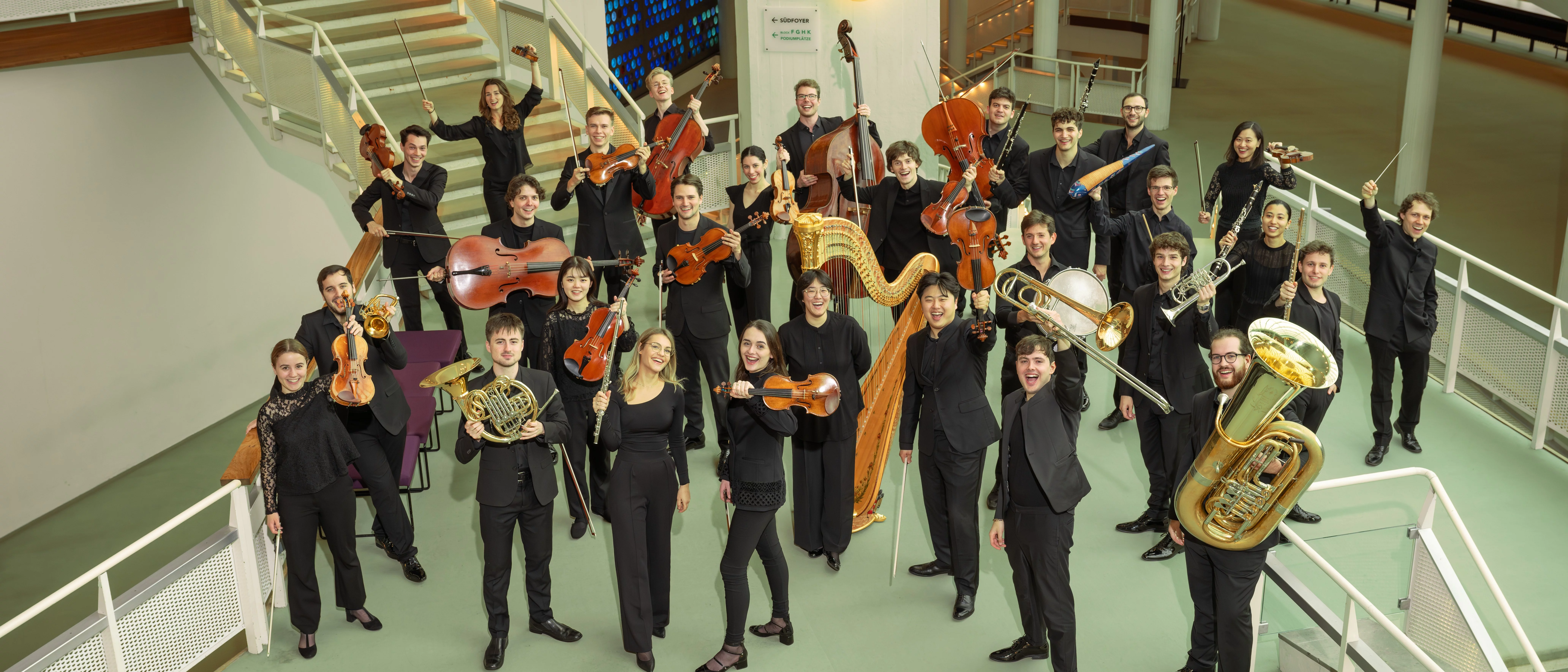 Group photo with musicians with their instruments in the foyer of the Philharmonie Berlin