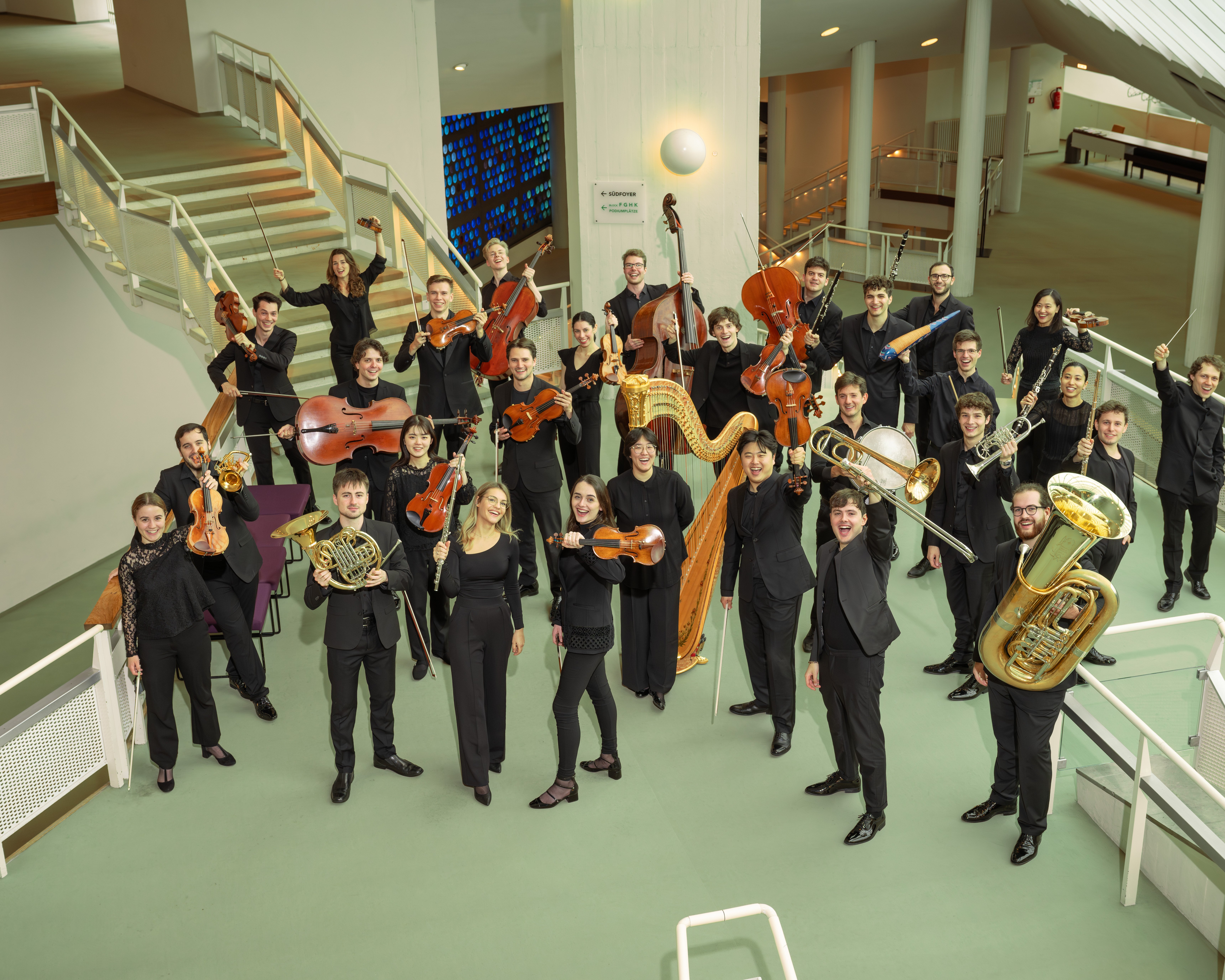 Group photo with musicians with their instruments in the foyer of the Philharmonie Berlin