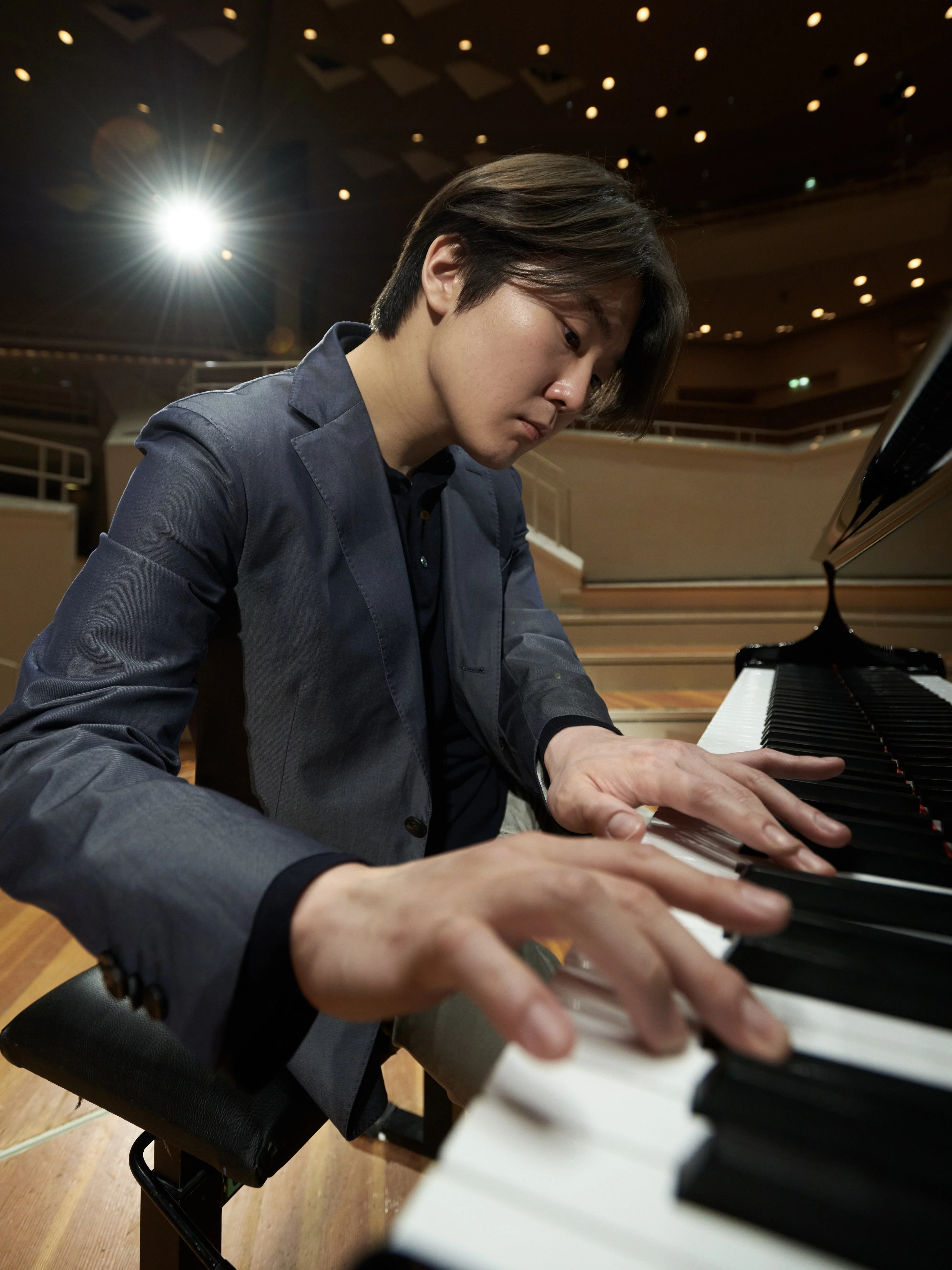 Pianist Seong-Jin Cho spielt an einem Flügel auf der leeren Bühne der Philharmonie.