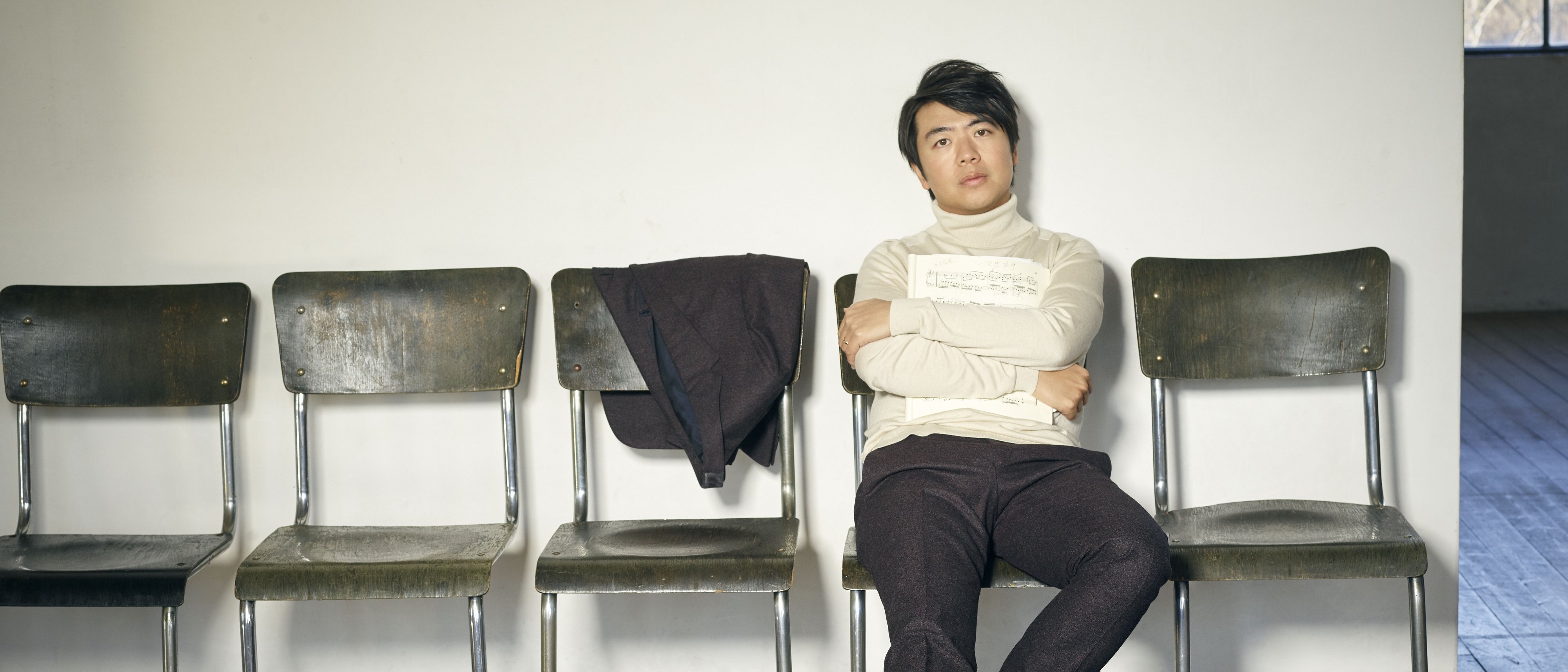 Lang Lang sits in a row of chairs