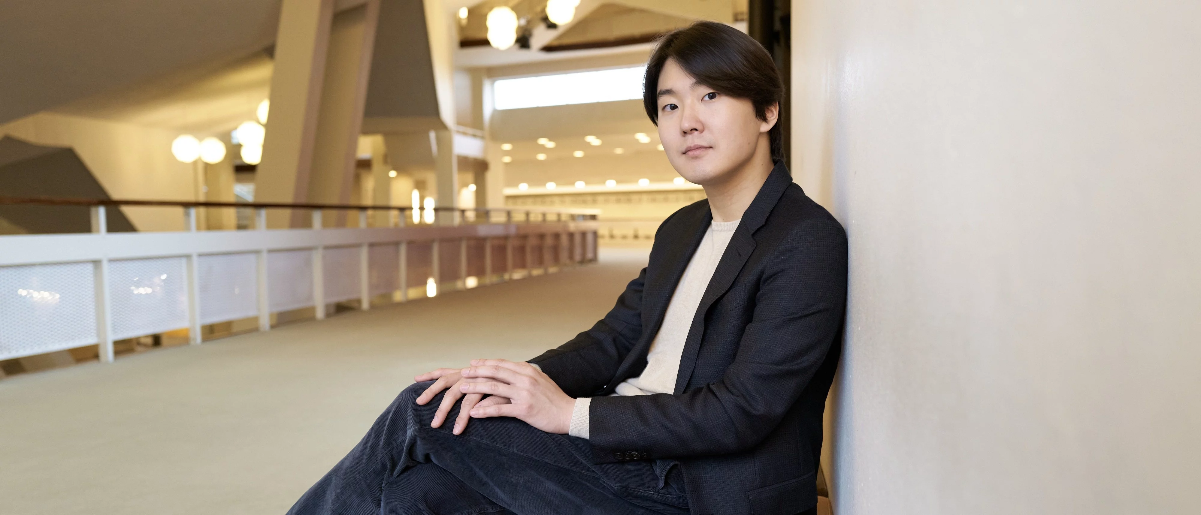 Seong-Jin Cho sits on a bench in the Philharmonie Berlin