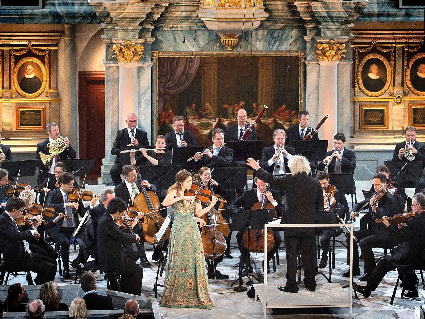 The orchestra with Vilde Frang and Simon Rattle on stage.