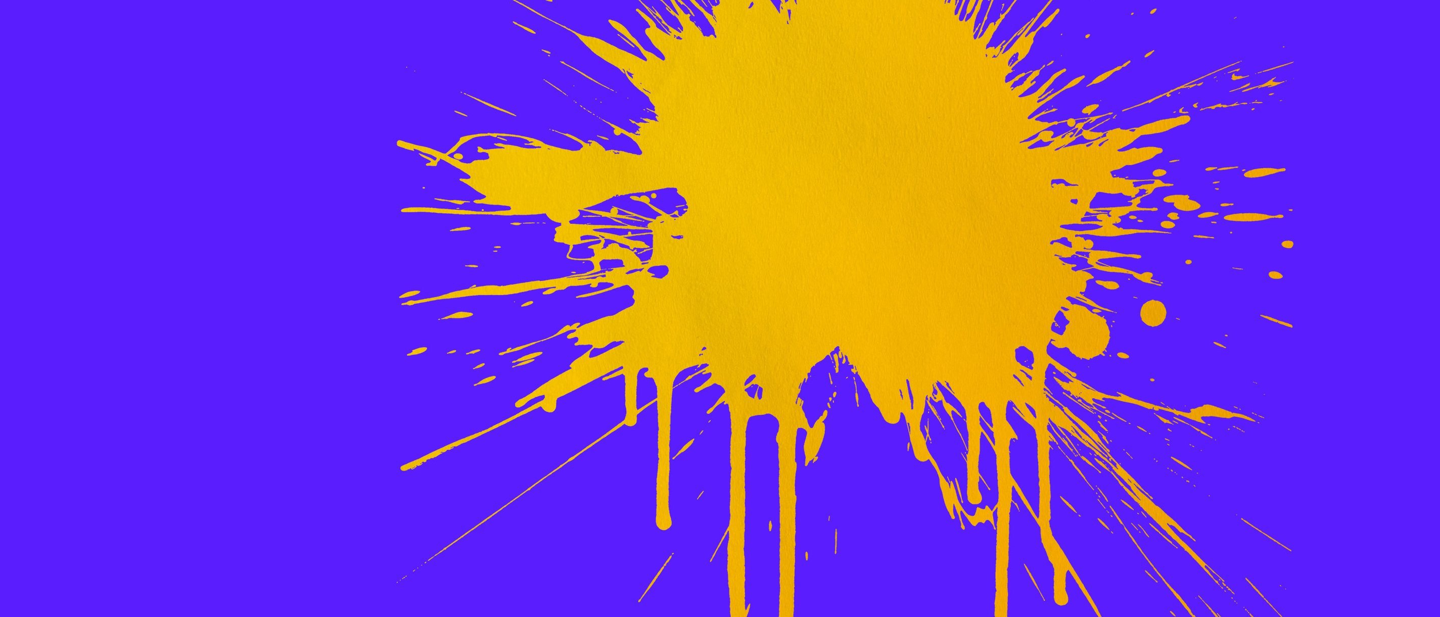 A large, vibrant yellow paint splatter with dripping streaks appears on a solid bright blue background, positioned towards the right side of the image.