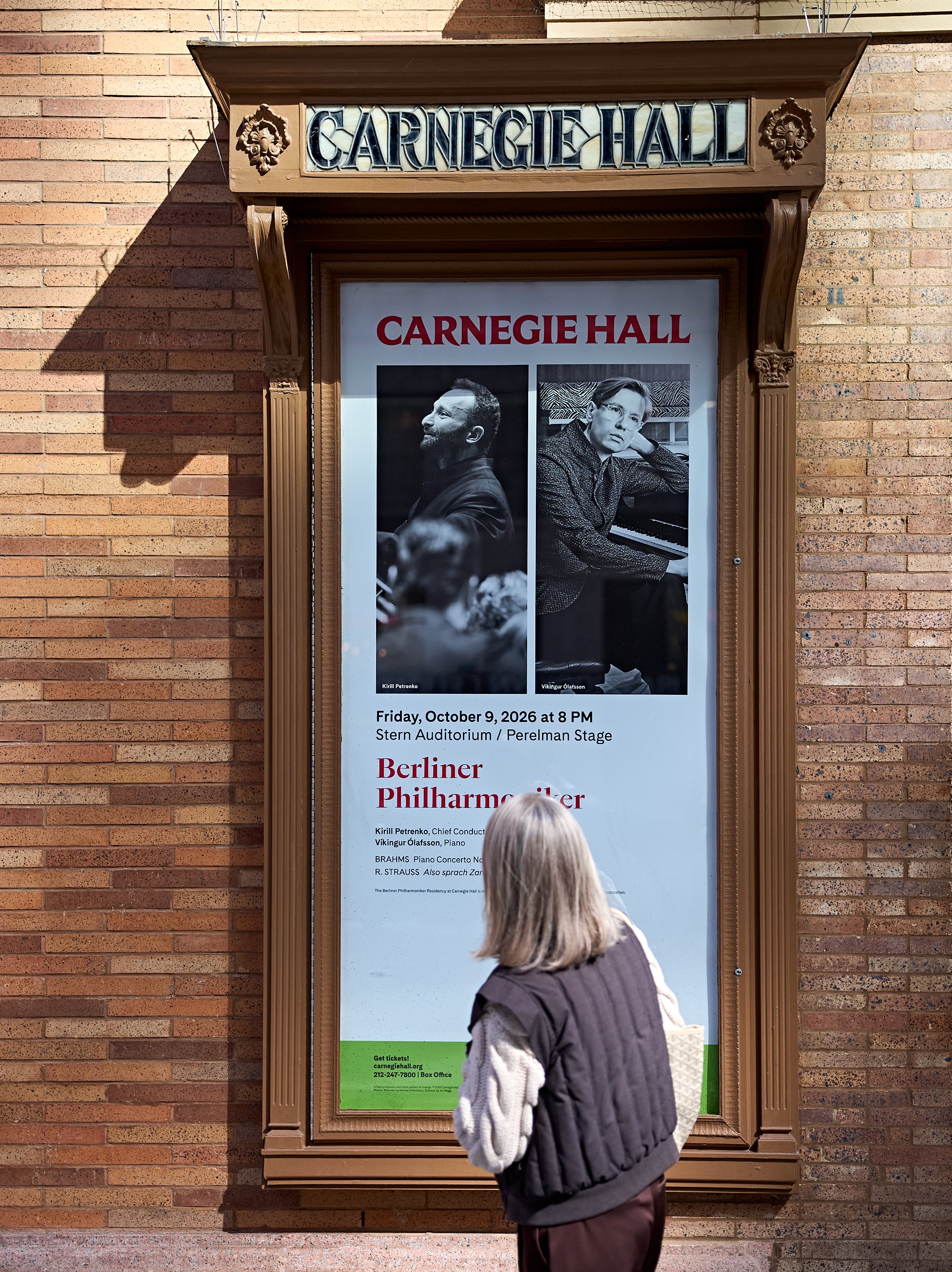 Eine Person betrachtet ein Veranstaltungsplakat der Carnegie Hall für ein Konzert der Berliner Philharmoniker am 9. Oktober 2026.