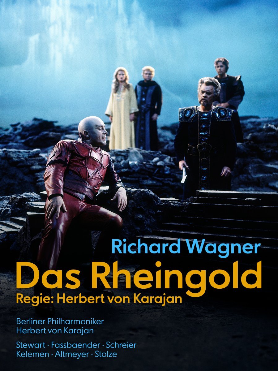 Fünf Operndarsteller in dramatischen Kostümen stehen auf einer dunklen, nebligen Bühne mit blauer Beleuchtung. Der Text wirbt für Richard Wagners Das Rheingold, inszeniert von Herbert von Karajan.