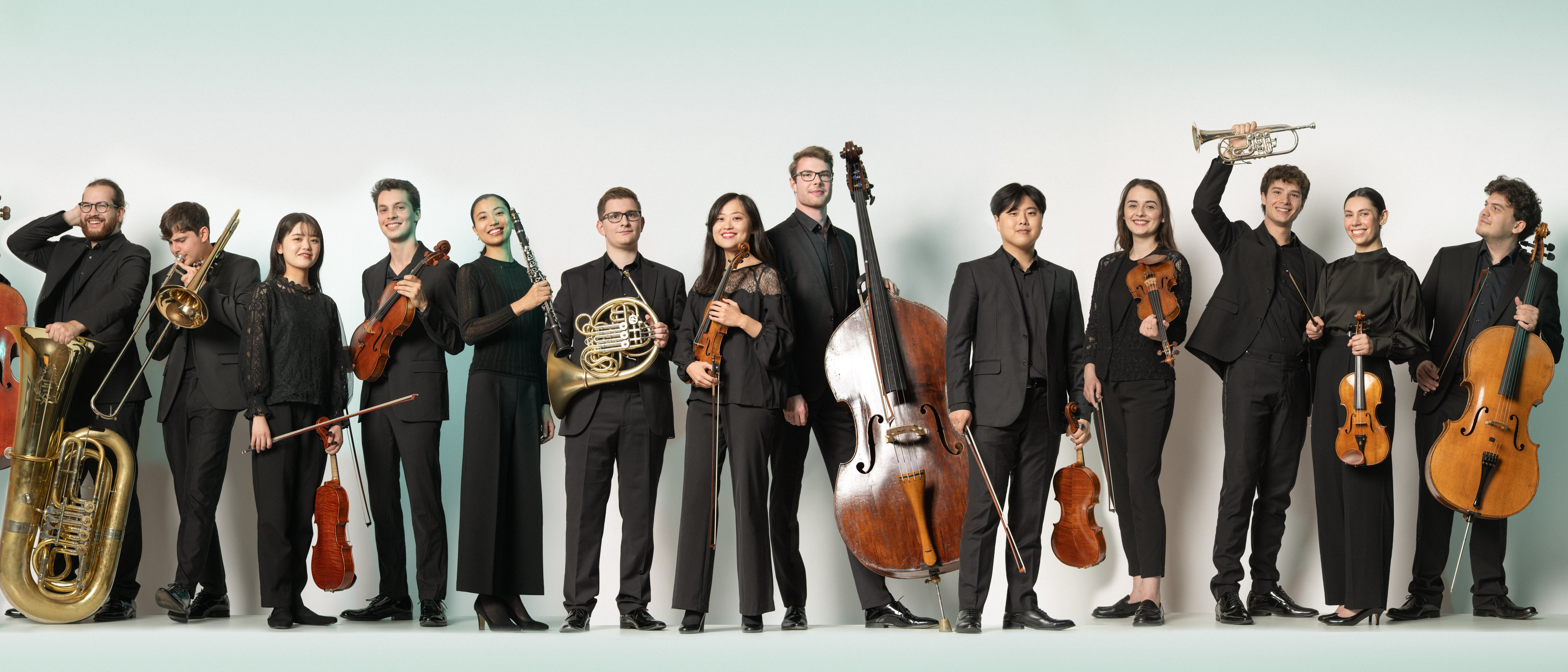 Junge Musiker*innen sind mit ihren Instrumenten nebeneinander aufgereiht