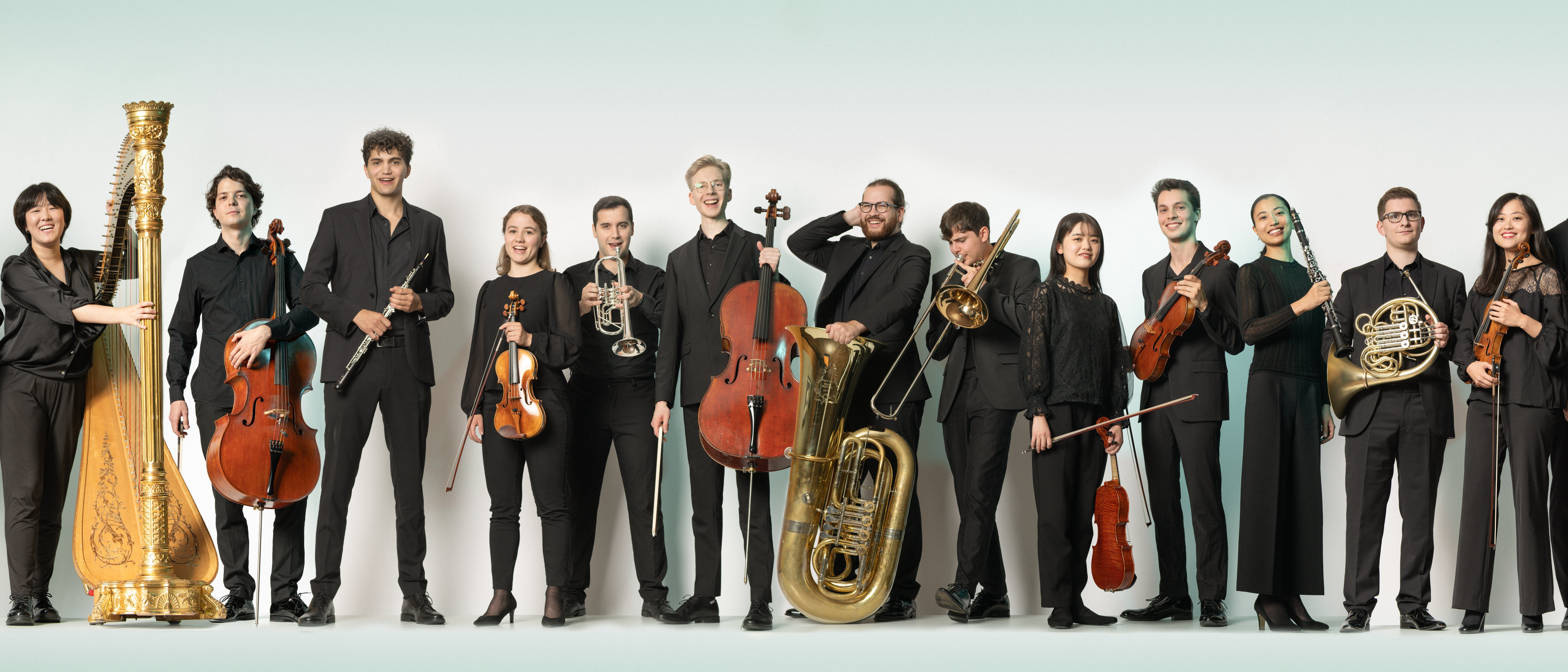 Junge Musiker*innen sind mit ihren Instrumenten nebeneinander aufgereiht