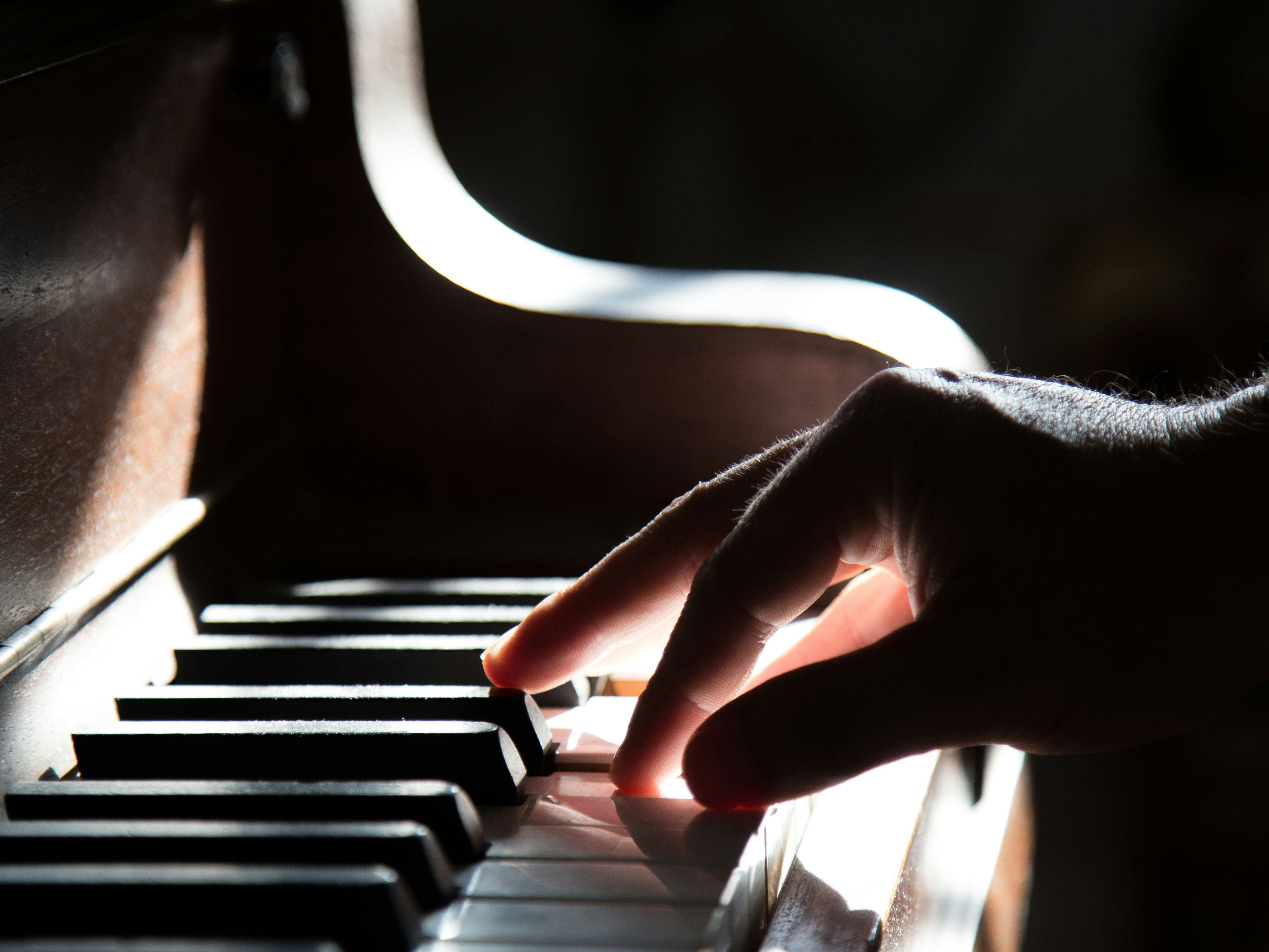Hand drückt Tasten auf einem Klavier
