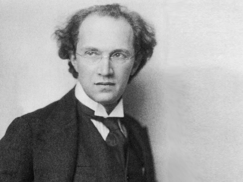 Schwarz-weiß Porträt von Franz Schreker. Er trägt einen Anzug mit Krawatte, zu seiner rechten Seite schauend.