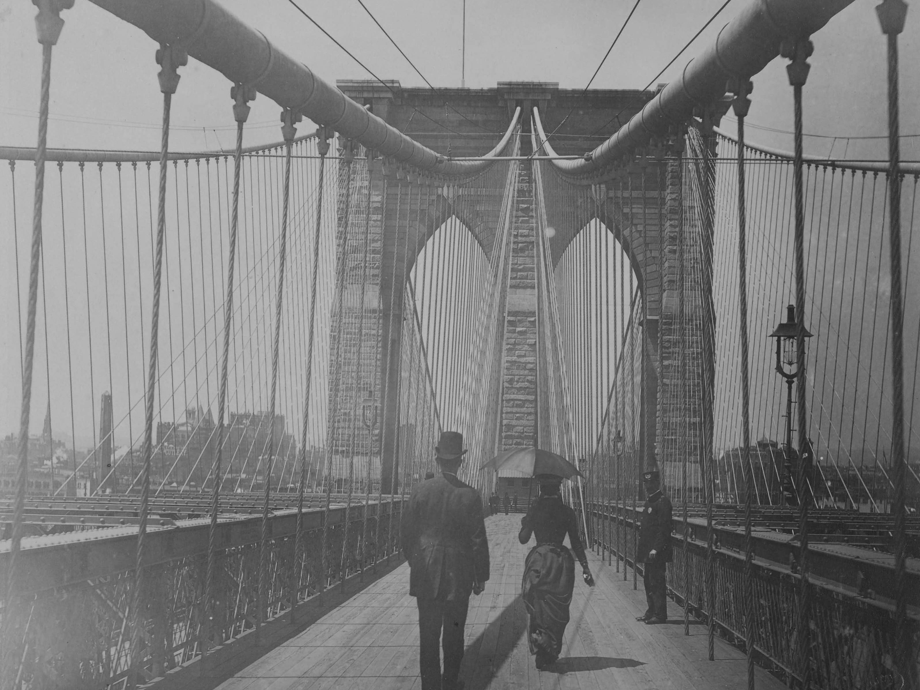 On the Brooklyn Bridge. Three people can be recognised.