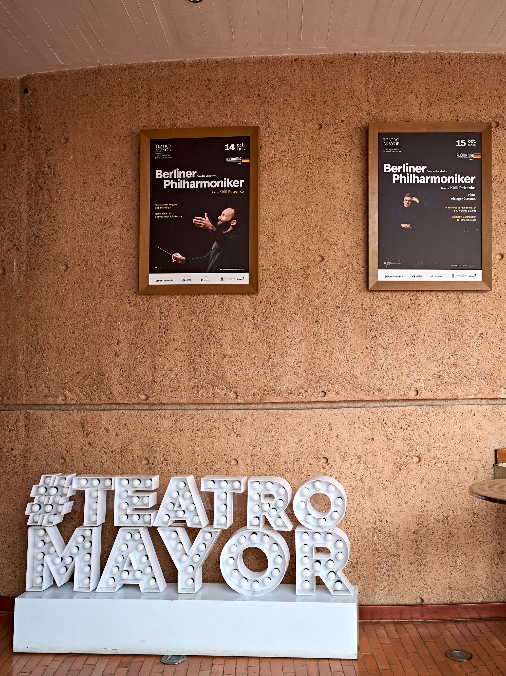 Zwei Konzertplakate der Berliner Philharmoniker hängen an einer Betonwand über einem großen, beleuchteten Schild mit der Aufschrift #TEATRO MAYOR.