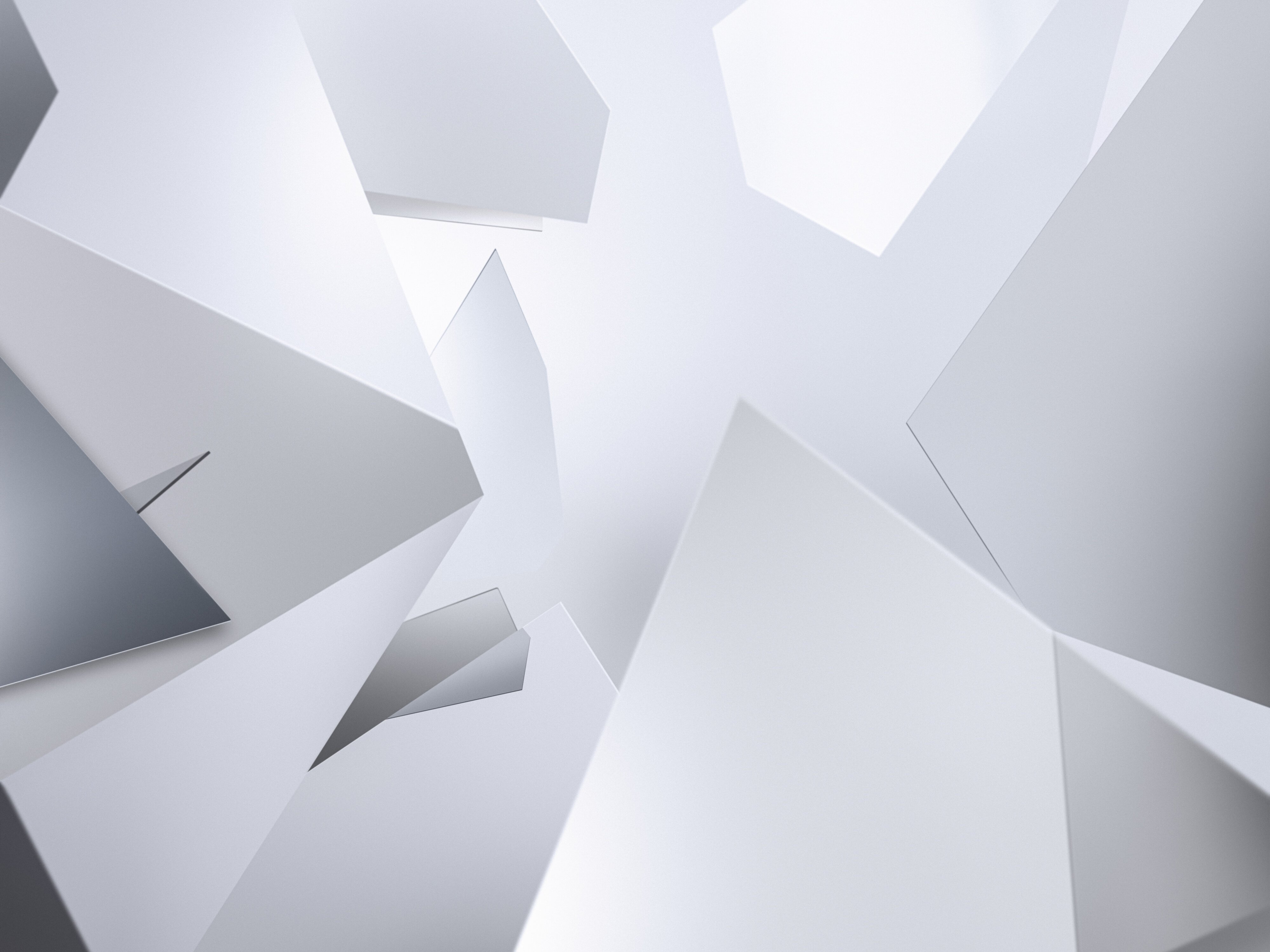 Abstraktes Bild aus scharfkantigen, sich überlagernden weißen und grauen geometrischen Formen, die ein Gefühl von Tiefe und Dimension vermitteln, wobei das Licht sanft von den Oberflächen reflektiert wird.