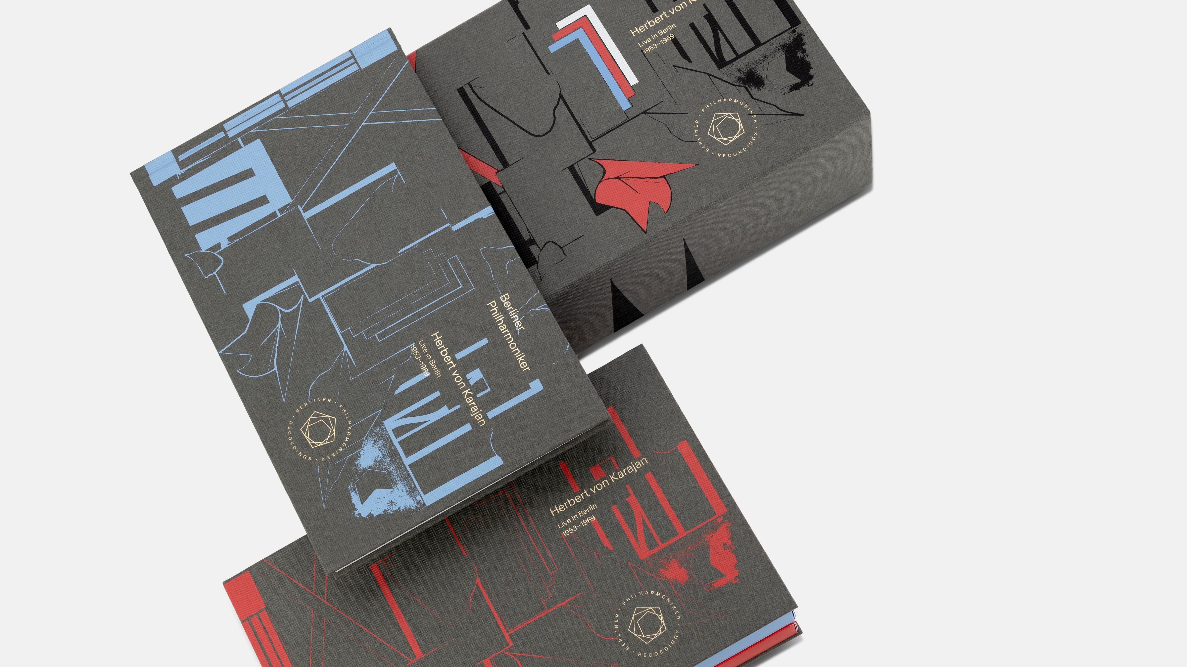 Drei aufwendig gestaltete Editionsboxen mit abstrakten blauen und roten Linienillustrationen und goldenen kreisförmigen Logos sind auf weißem Hintergrund angeordnet und überlagern sich teilweise.