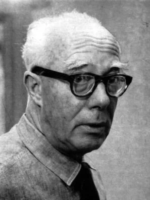 Fotografie von Roberto Gerhard mit dickrandiger Brille und Hemd. Er schaut von der Seite in die Kamera