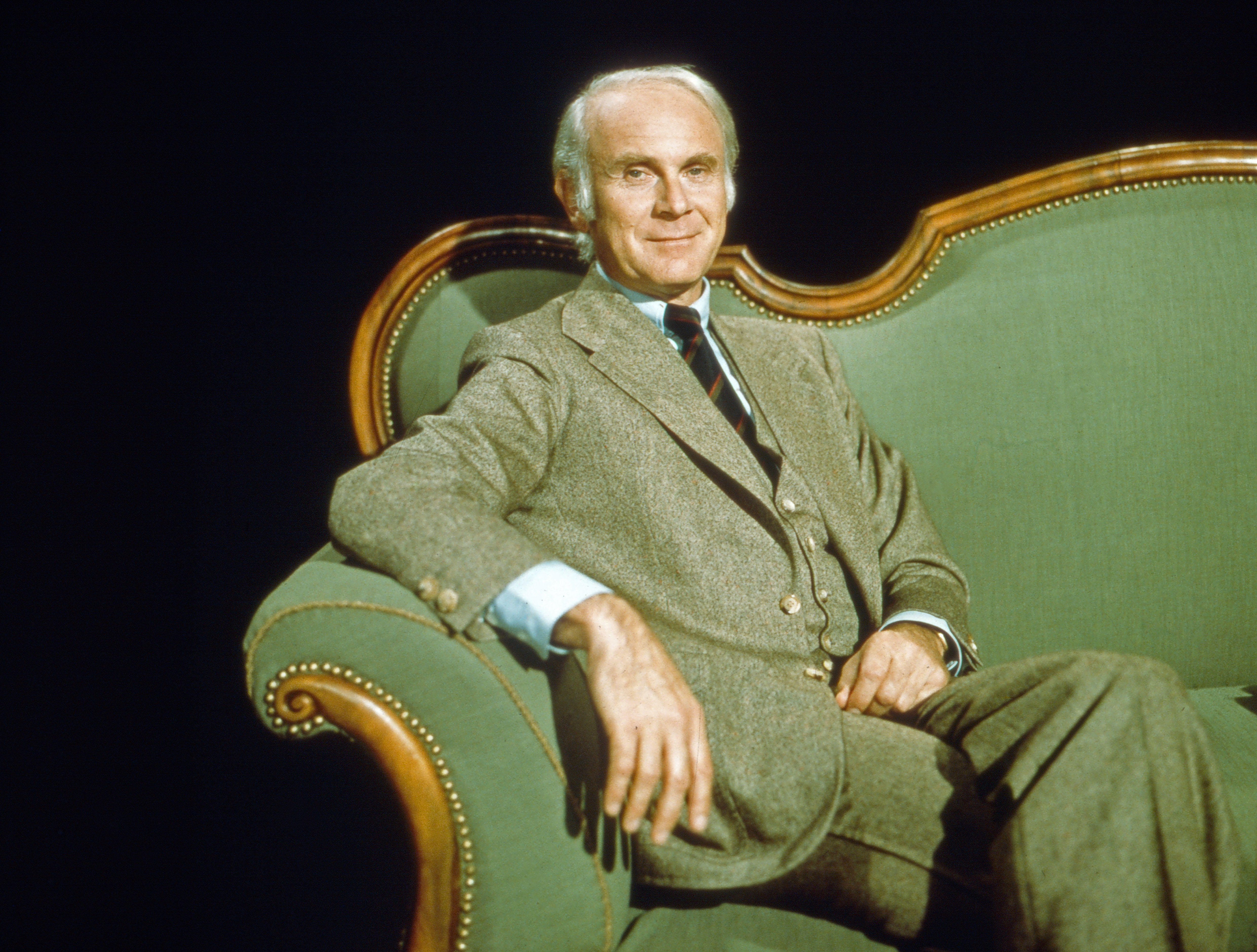 Loriot sitzt auf einem alten grünen Sofa