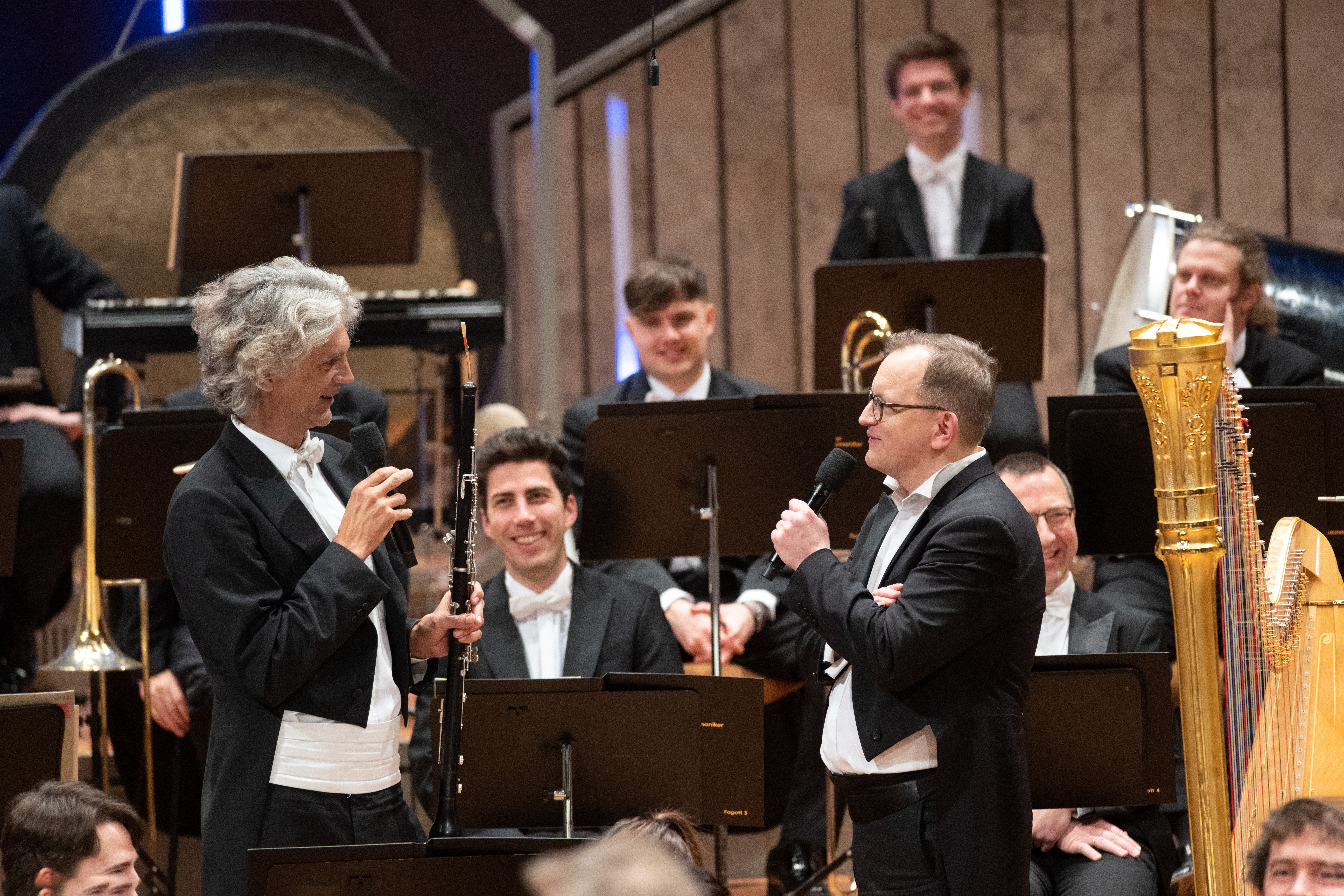 Zwei Musiker im Frack sprechen miteinander mit Mikrophonen