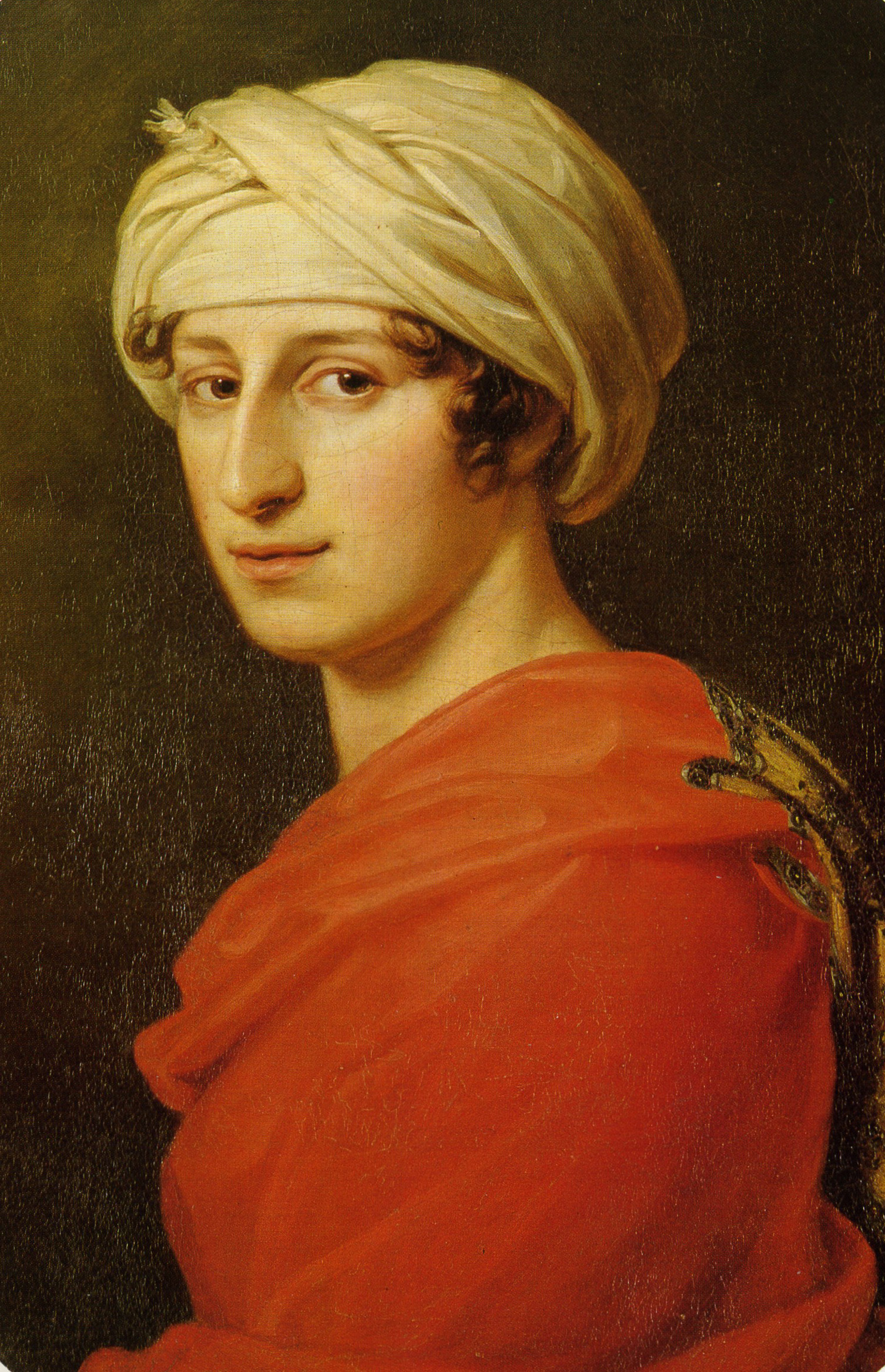 Eine Person, die einen cremefarbenen Turban und ein rotes Gewand mit goldenen Verzierungen trägt, blickt den Betrachter vor einem dunklen, schlichten Hintergrund sanft an. Das Porträt ist im klassischen Stil gemalt.