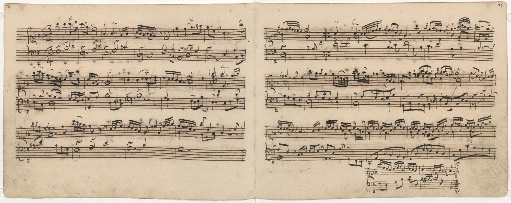 Aged sheet music with handwritten musical notes in black ink, spread across two pages. The notes form complex, flowing melodies. The paper shows slight discoloration and worn edges.