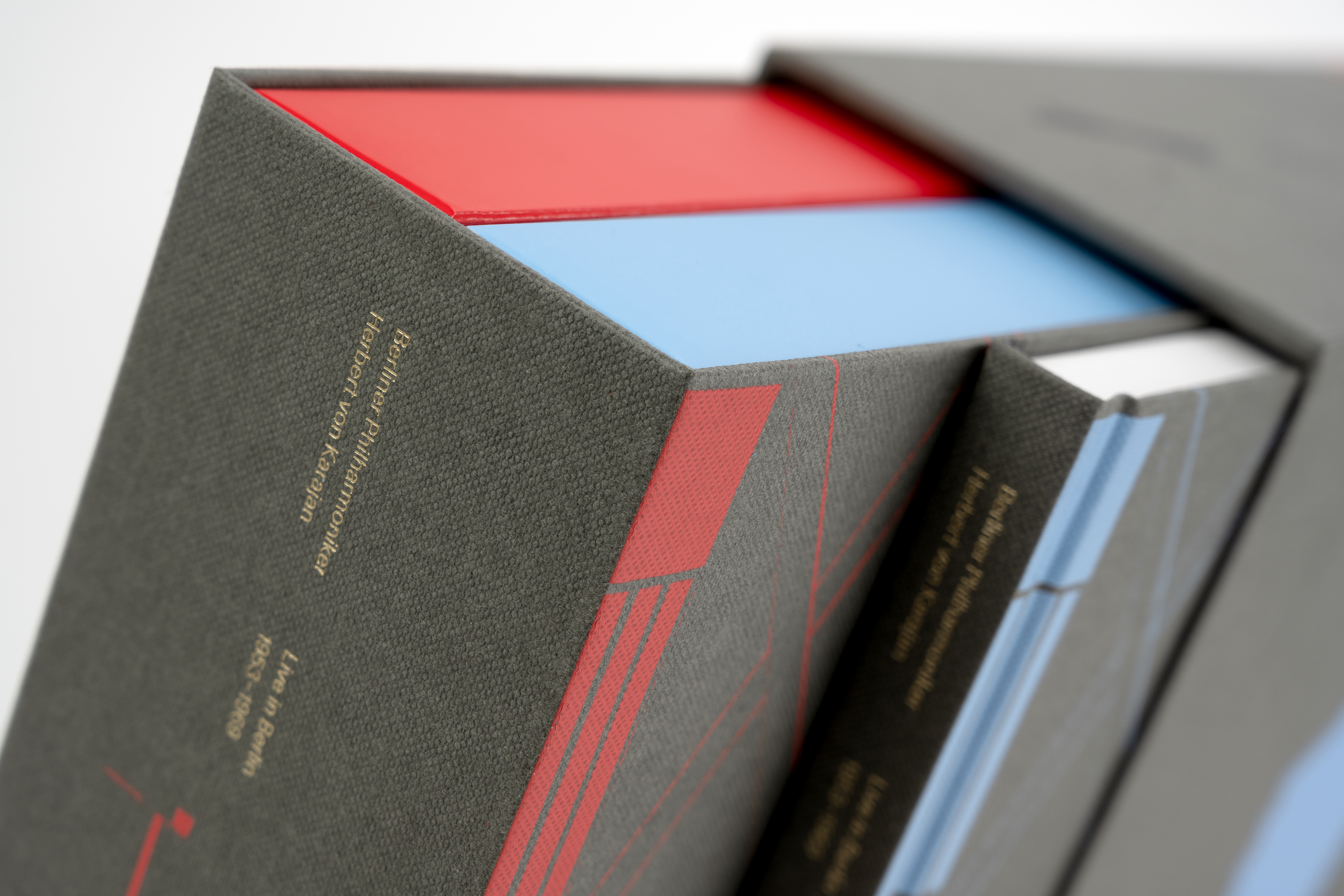 Close-up of the box edition ‘Herbert von Karajan - Live in Berlin 1953-1960’ by the Berliner Philharmoniker. The coloured cut edges of the books and the fine linen structure with golden embossing are visible.