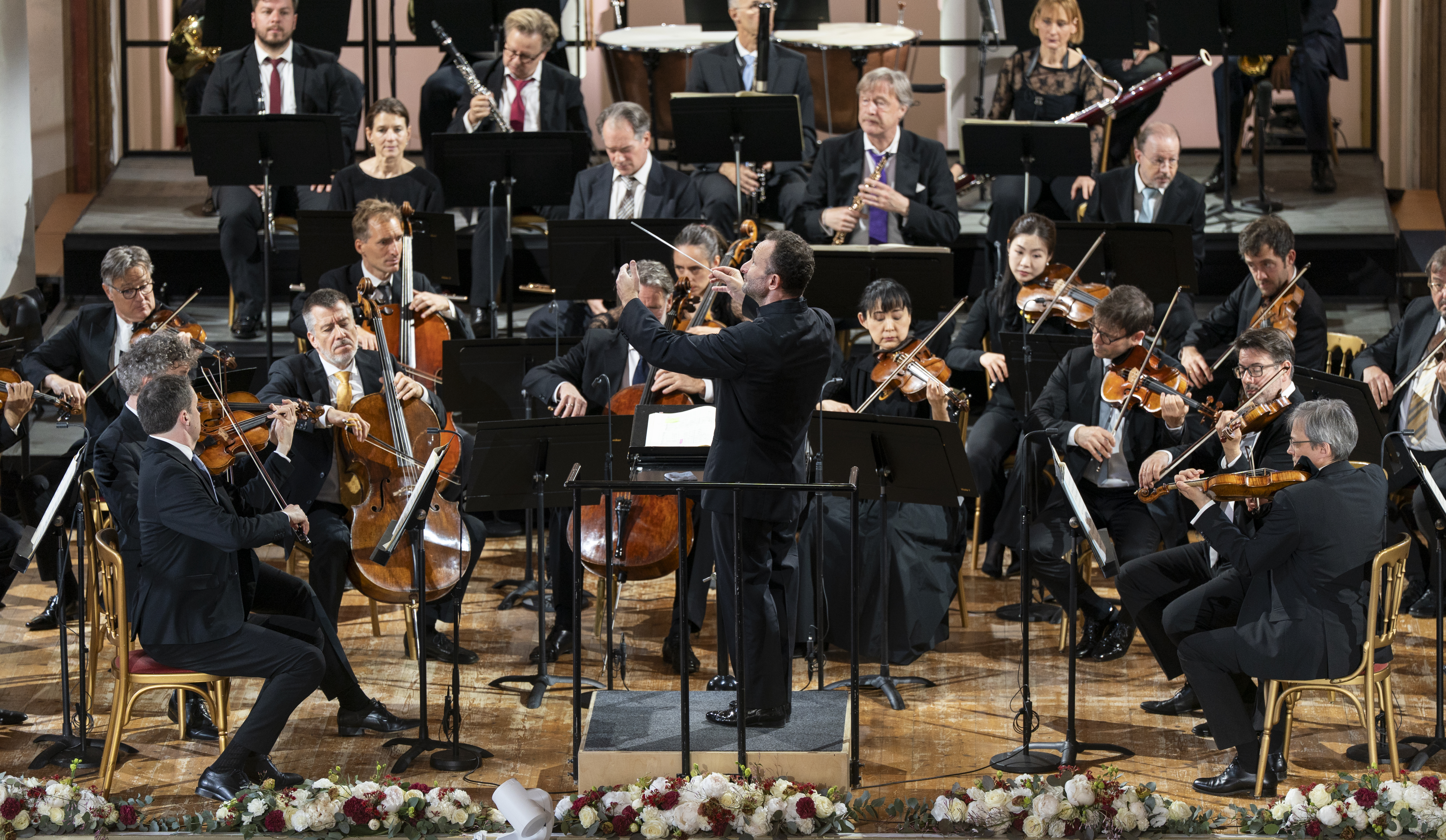 Chefdirient Kirill Petrenko dirigiert das Orchester auf der Bühne.