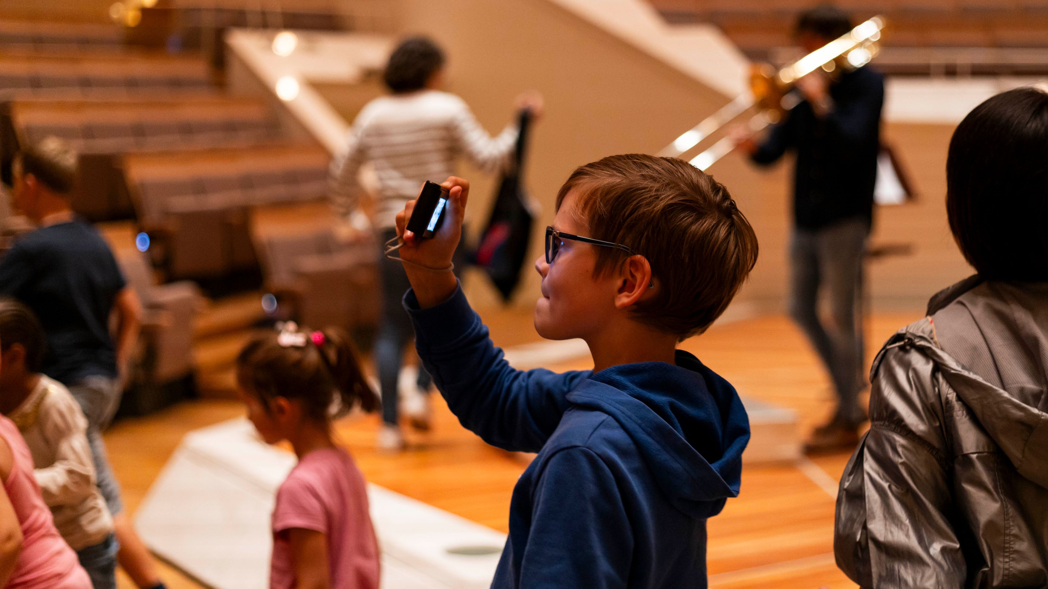 Junge macht mit seinem Handy ein Foto in der Philharmonie.