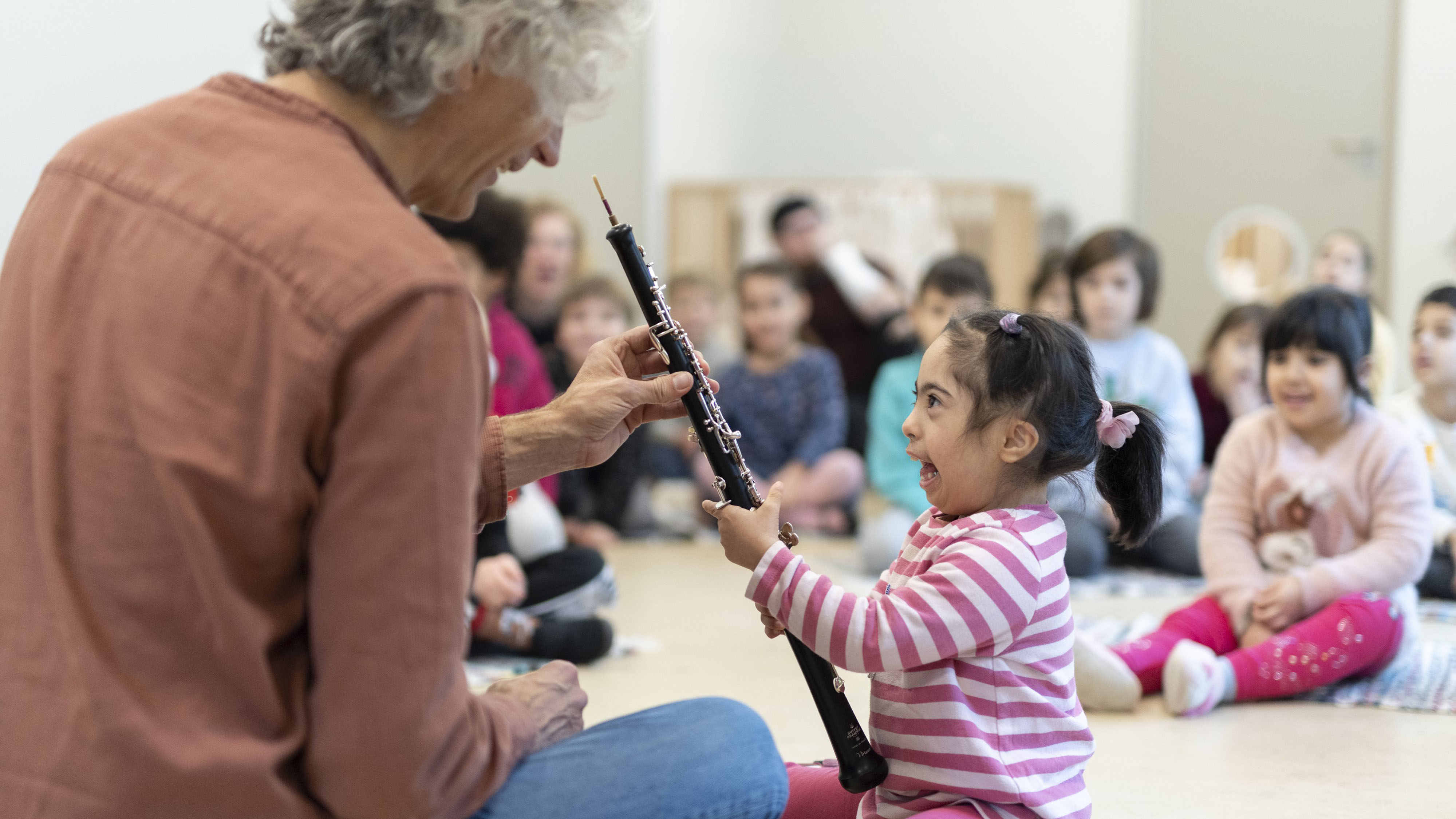 Musiker zeigt kleinem Kind eine Oboe